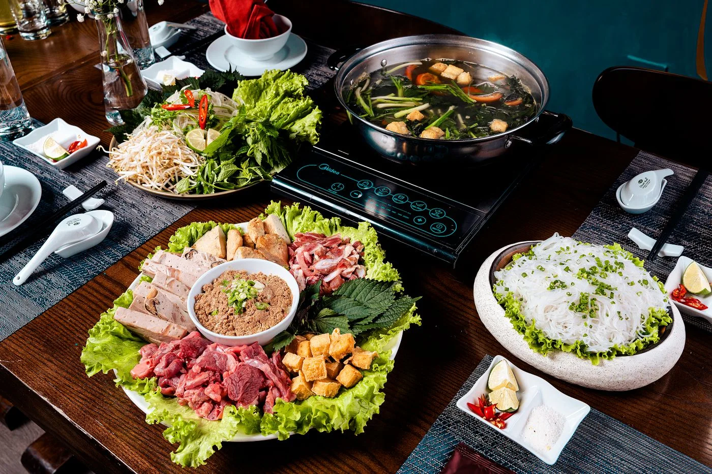 餐桌上的火鍋、肉片、蔬菜與配料