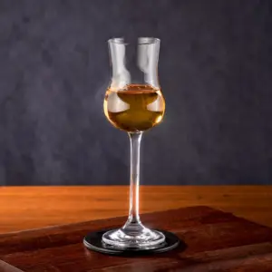 木質桌面上的高腳品飲杯,盛著琥珀色酒液