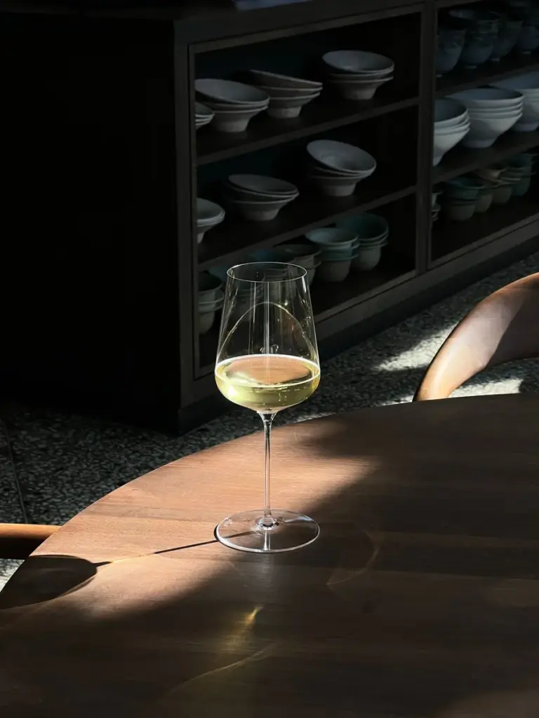 陽光下木桌上的一杯白葡萄酒